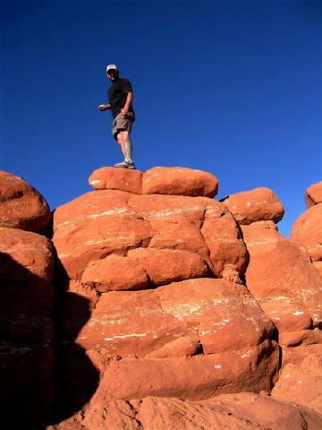 Marc Olivares stand on top of a hoodoo.